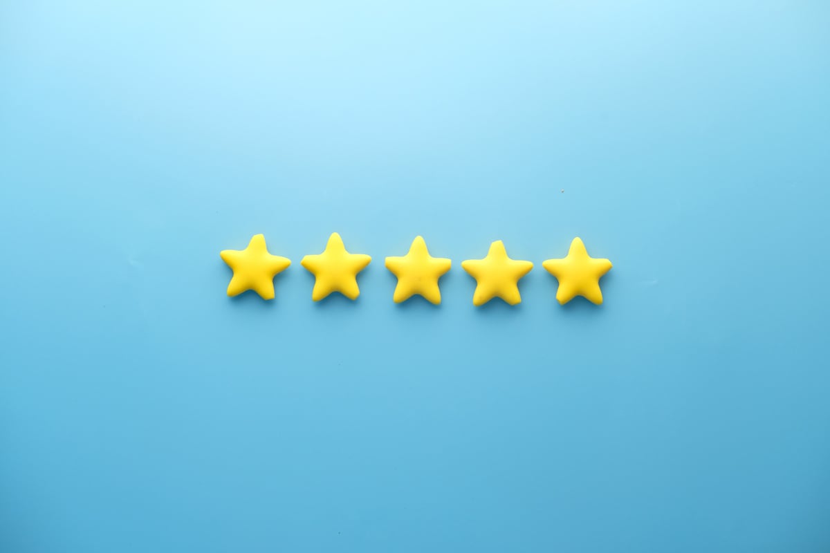 Customer Review Concept. Rating Golden Stars on Blue Background